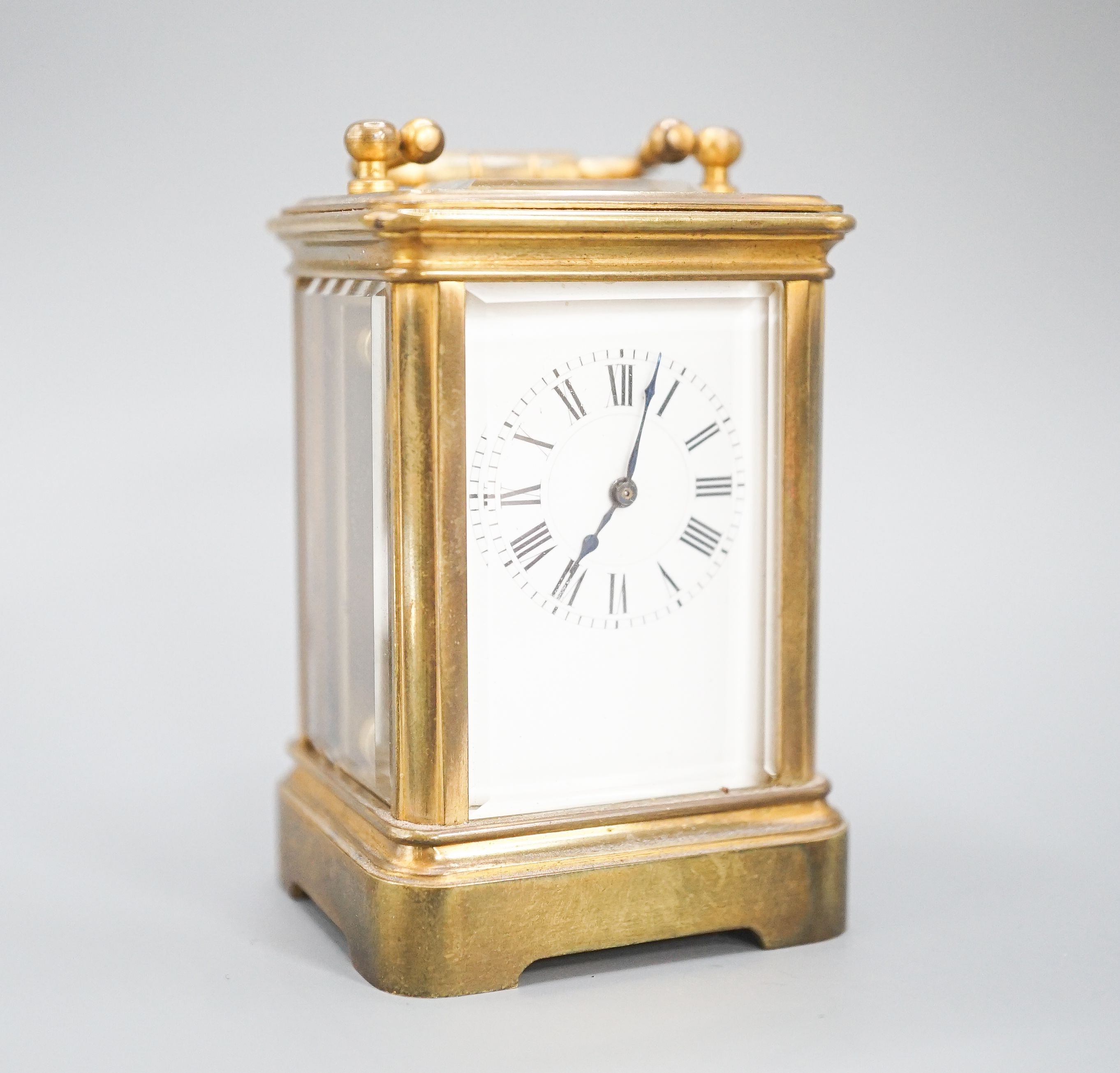 A Henri Jacot brass miniature carriage timepiece, 9.7 cm high with the handle up, cased